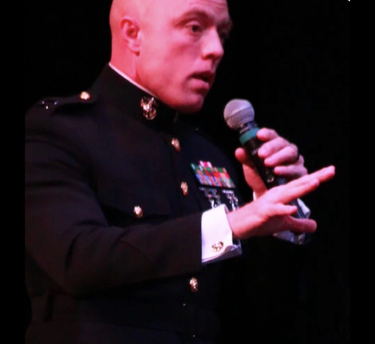 CoachCam Campbell speaking in uniform with a microphone